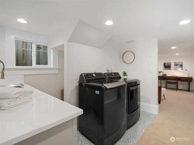 washroom with sink, light colored carpet, and washing machine and dryer