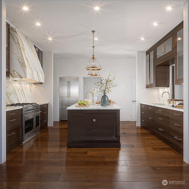 kitchen featuring sink, dark wood-type flooring, a center island, high end appliances, and custom range hood