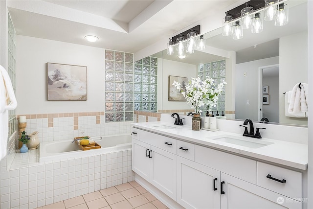 bathroom with vanity, tile patterned flooring, and a relaxing tiled tub