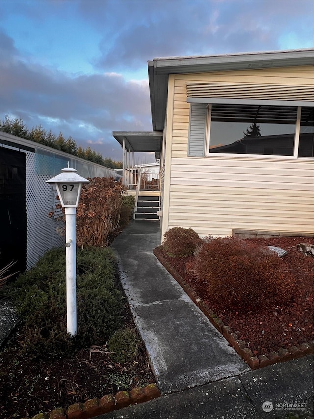 property exterior at dusk featuring covered porch