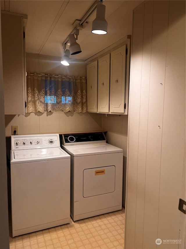 laundry area featuring cabinets, track lighting, and washing machine and clothes dryer