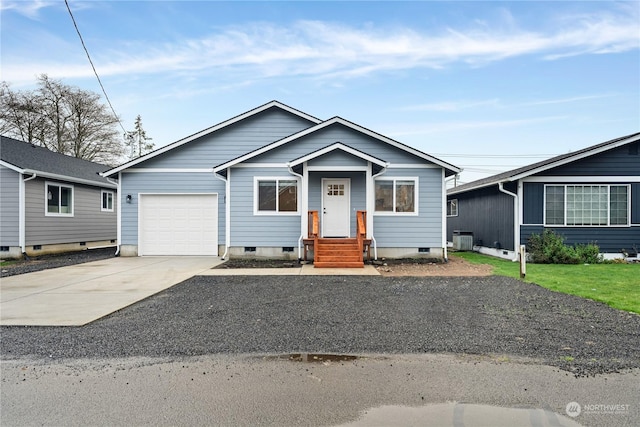 view of front of property with concrete driveway, central AC unit, and an attached garage