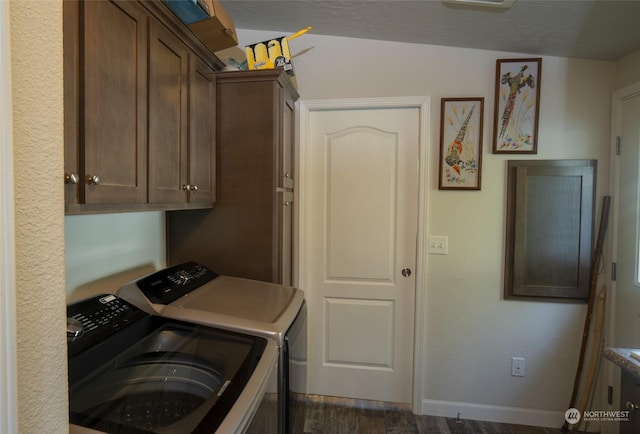 laundry room featuring dark hardwood / wood-style floors, cabinets, and washing machine and clothes dryer