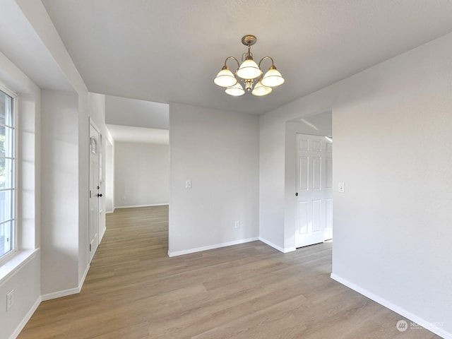 unfurnished dining area featuring wood-type flooring and a chandelier