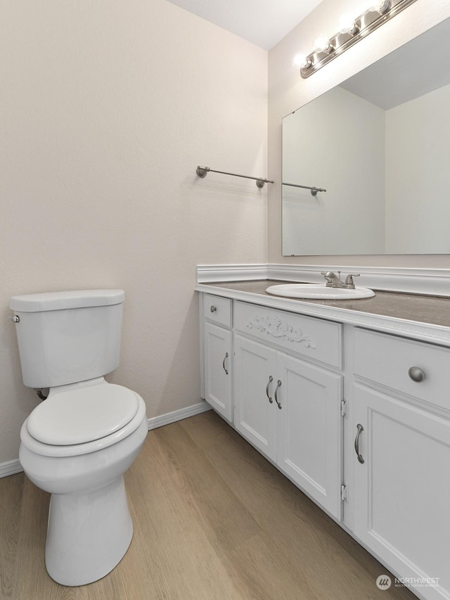 bathroom featuring hardwood / wood-style flooring, vanity, and toilet