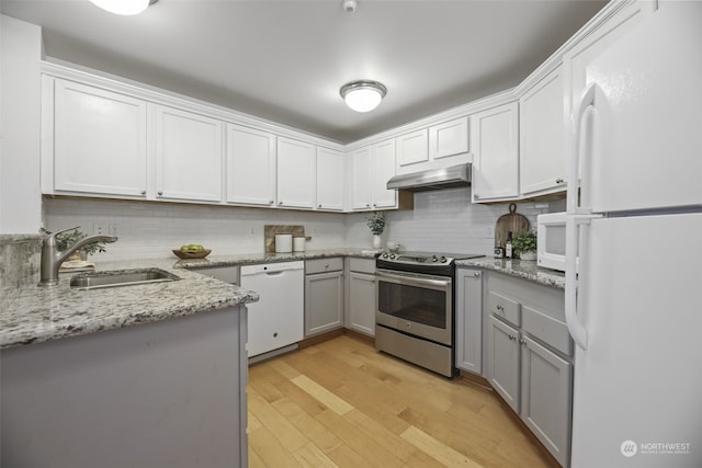 kitchen with sink, white cabinetry, light wood-type flooring, white appliances, and decorative backsplash