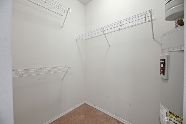 walk in closet featuring carpet flooring and electric water heater