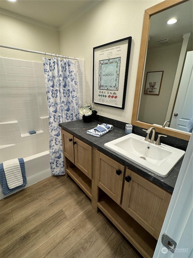 bathroom with vanity, wood-type flooring, shower / tub combo, and ornamental molding