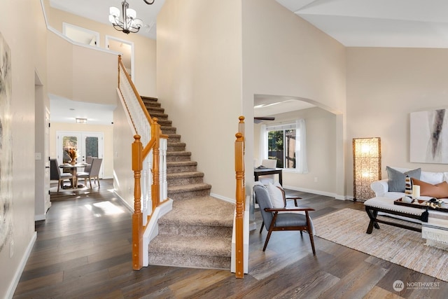 foyer featuring french doors, high vaulted ceiling, dark hardwood / wood-style floors, and an inviting chandelier