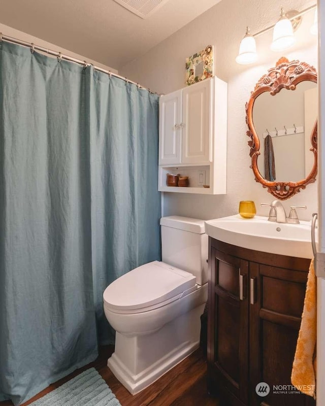 bathroom with wood-type flooring, toilet, vanity, and a shower with shower curtain