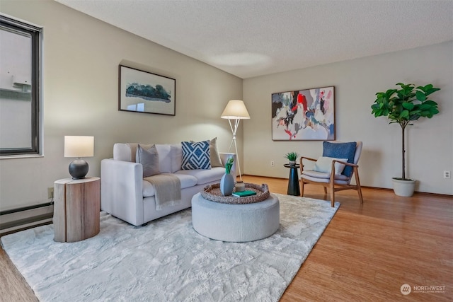 living room with hardwood / wood-style floors, a textured ceiling, and a baseboard radiator