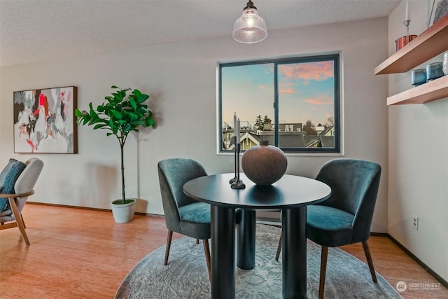 dining area featuring a textured ceiling and hardwood / wood-style flooring