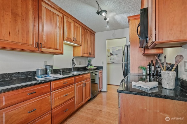 kitchen with rail lighting, dark stone counters, a textured ceiling, sink, and black appliances