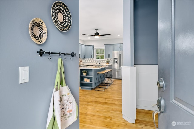 bathroom featuring sink, hardwood / wood-style flooring, ceiling fan, and decorative backsplash