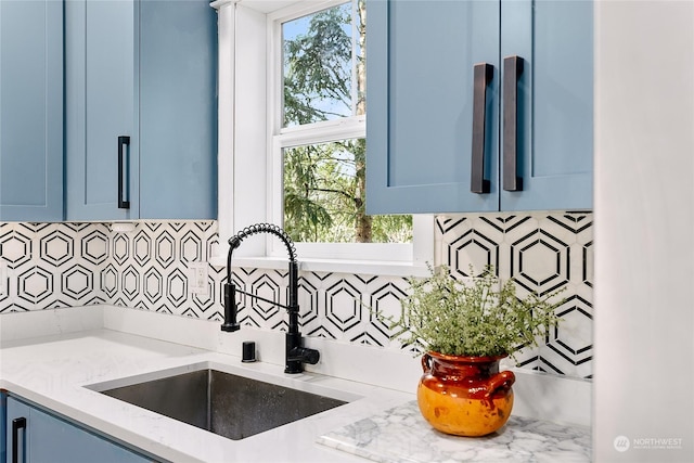 kitchen featuring sink, a wealth of natural light, blue cabinets, and light stone counters