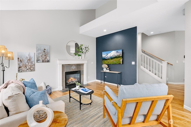 living room with a tiled fireplace and light hardwood / wood-style floors