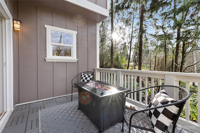 wooden balcony featuring a fire pit and a wooden deck