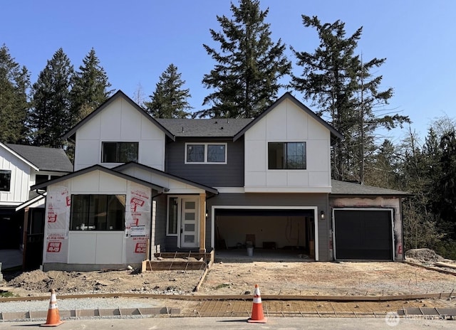 21017 67th Street Ct E, Bonney Lake, WA 98391 - view of front of house with board and batten siding, dirt driveway, and an attached garage