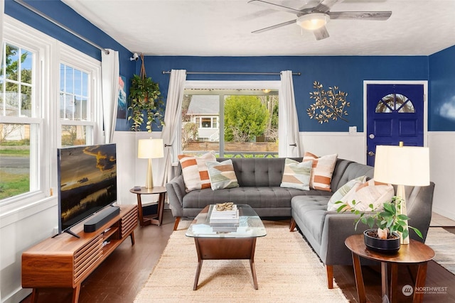 living room featuring wood-type flooring, ceiling fan, and a healthy amount of sunlight