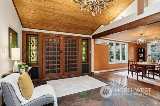 interior space with wooden ceiling, vaulted ceiling, a chandelier, and a wall mounted air conditioner