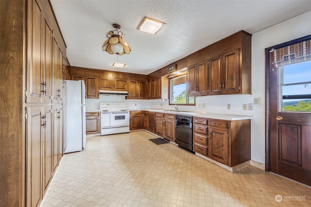 kitchen with sink, white appliances, and a textured ceiling