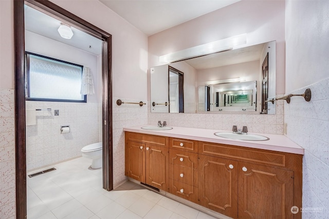 bathroom featuring tile walls, vanity, and toilet