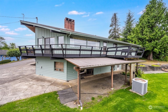 back of property featuring a wooden deck, a lawn, and central air condition unit