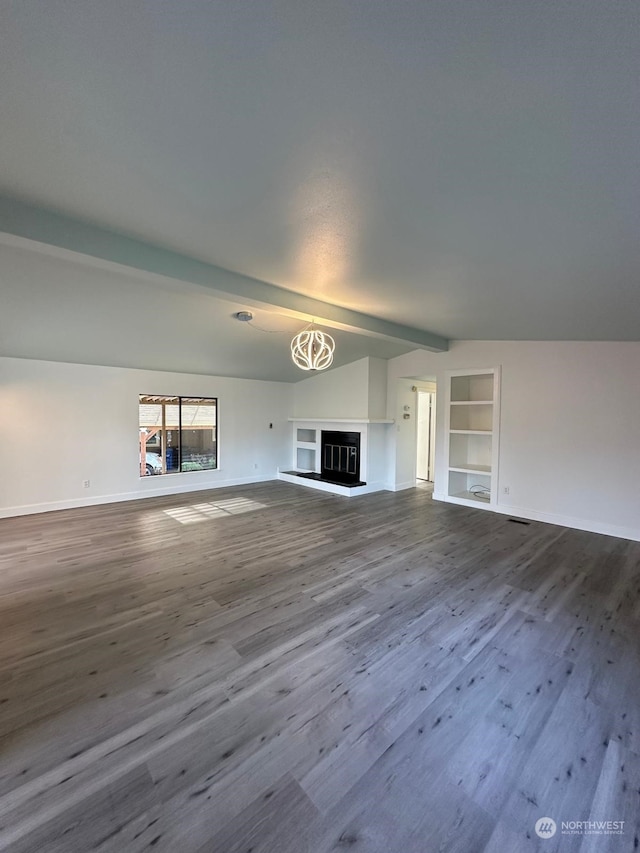 unfurnished living room with lofted ceiling with beams, built in features, and wood-type flooring