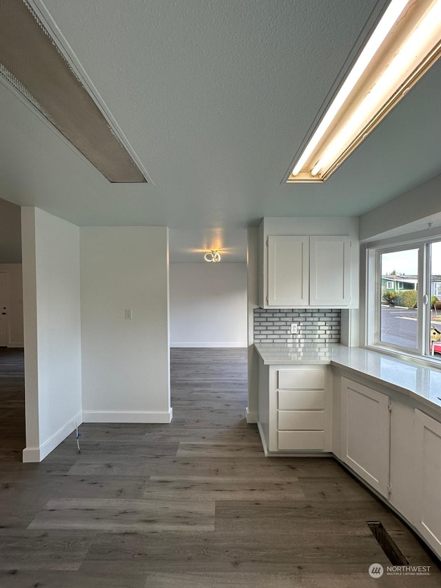 kitchen with decorative backsplash, white cabinets, and dark wood-type flooring