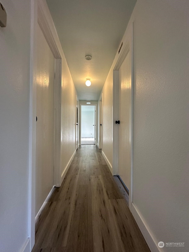 hallway with hardwood / wood-style flooring