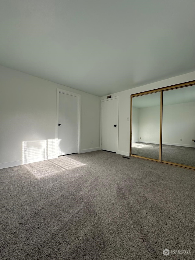 unfurnished bedroom featuring carpet flooring and a closet