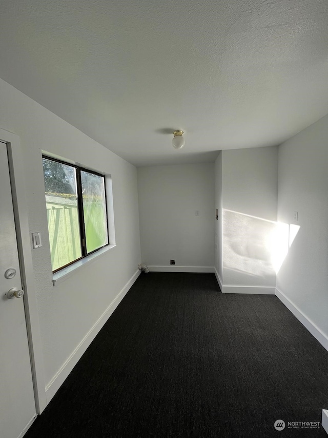 carpeted empty room featuring a textured ceiling