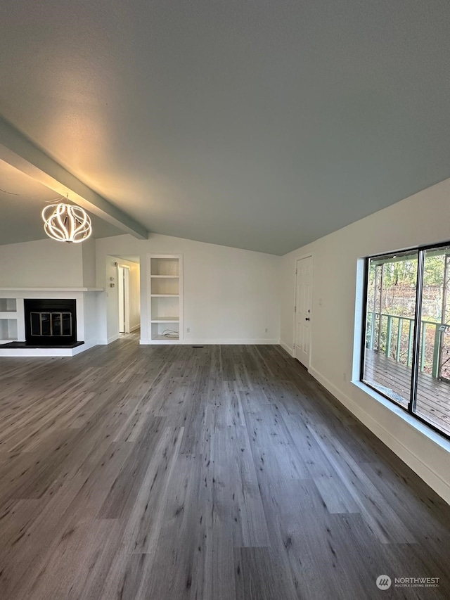 unfurnished living room featuring hardwood / wood-style flooring, vaulted ceiling with beams, built in features, and a notable chandelier