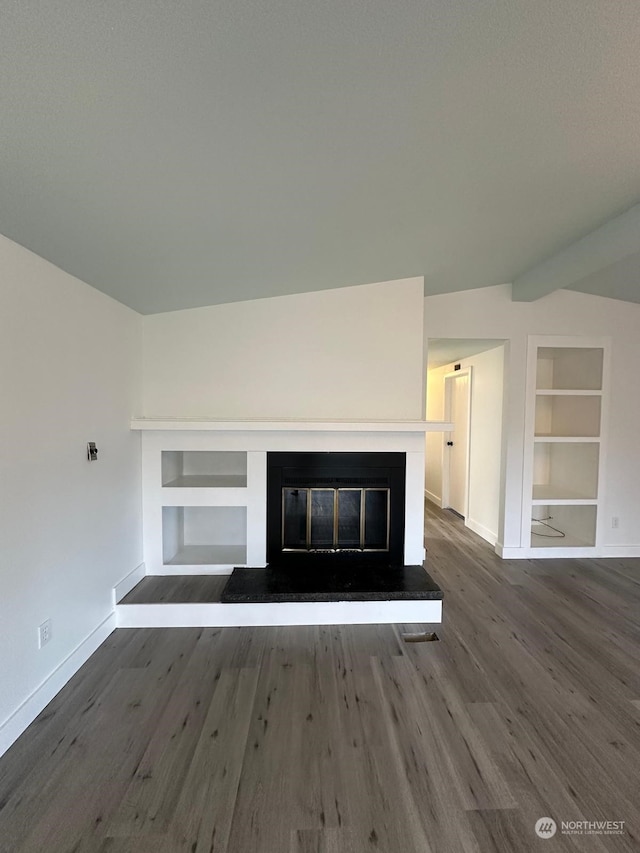 unfurnished living room featuring built in shelves, dark hardwood / wood-style floors, and vaulted ceiling