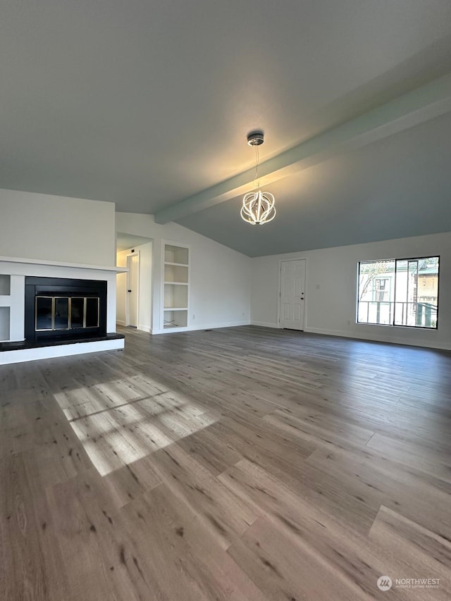 unfurnished living room with a chandelier, hardwood / wood-style floors, vaulted ceiling with beams, and built in shelves