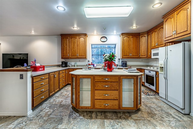 kitchen with a kitchen island, white appliances, and kitchen peninsula