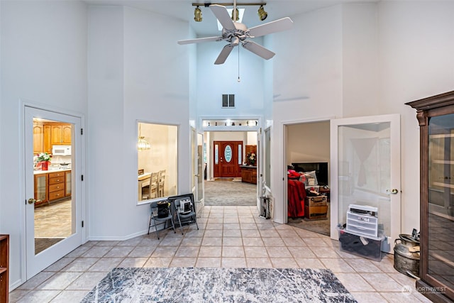 entryway featuring light tile patterned floors, french doors, high vaulted ceiling, and ceiling fan