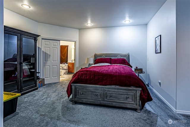 bedroom featuring dark colored carpet and ensuite bathroom