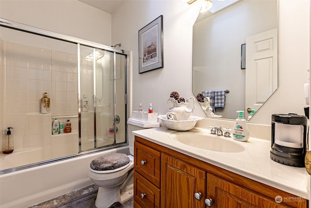 full bathroom featuring vanity, toilet, and bath / shower combo with glass door