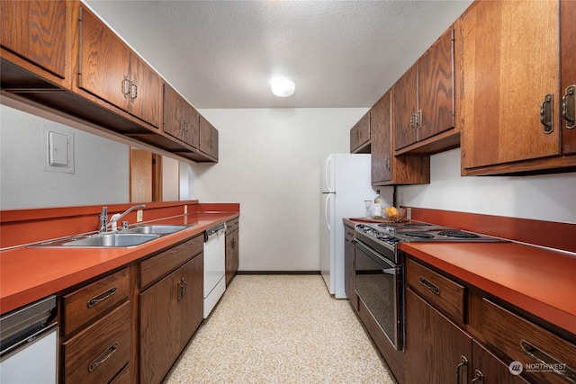 kitchen with a textured ceiling, white appliances, and sink