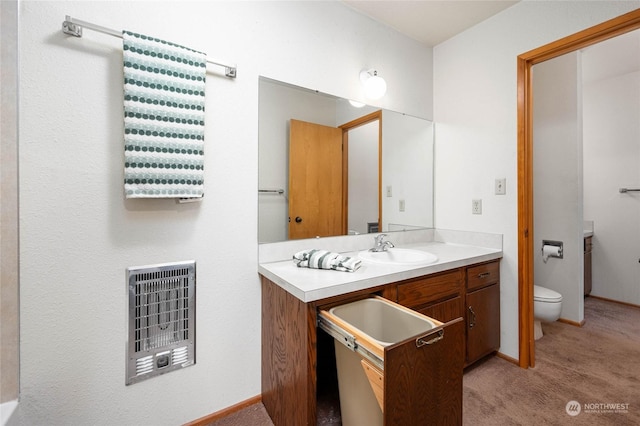 bathroom with vanity, toilet, and heating unit