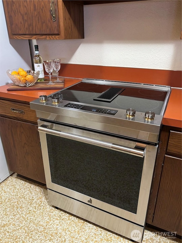 kitchen featuring dark brown cabinetry and electric stove