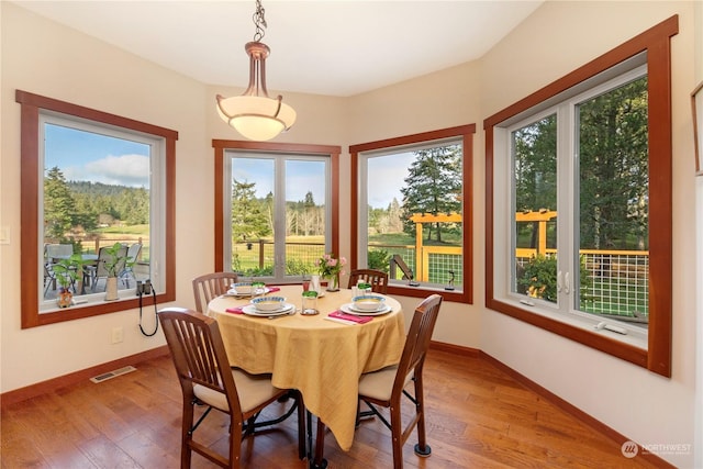 dining area featuring baseboards, visible vents, and hardwood / wood-style floors