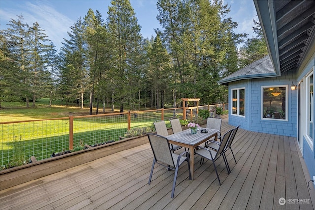 deck featuring outdoor dining space and a yard