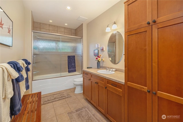 bathroom with recessed lighting, toilet, enclosed tub / shower combo, vanity, and tile patterned flooring