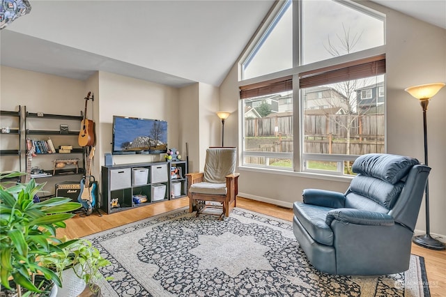 living area with hardwood / wood-style floors and vaulted ceiling