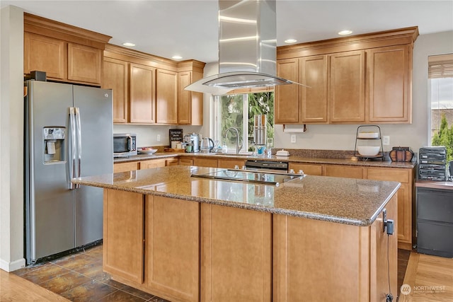 kitchen featuring island exhaust hood, stainless steel appliances, light stone countertops, a kitchen island, and sink