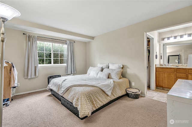 bedroom featuring a spacious closet, sink, and light carpet