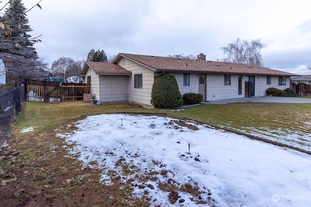 snow covered back of property with a lawn