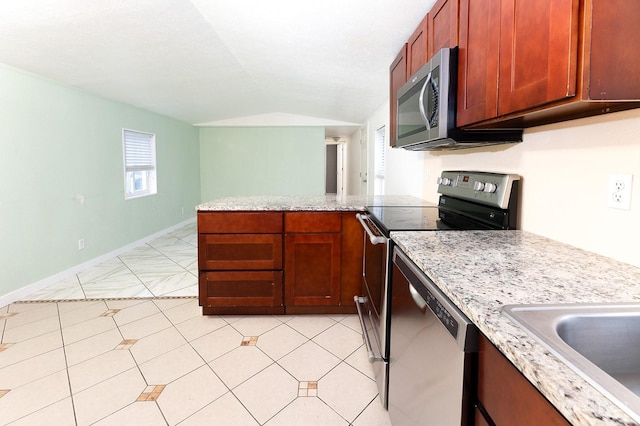 kitchen featuring light stone countertops, appliances with stainless steel finishes, lofted ceiling, sink, and kitchen peninsula